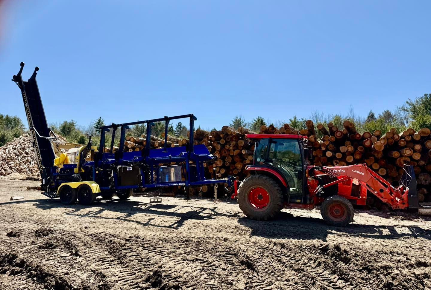 A tractor is pulling a trailer full of logs.