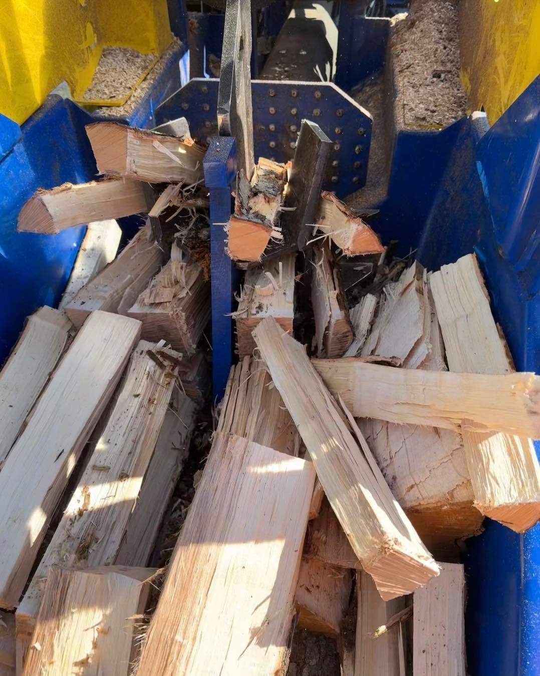 A pile of wood is being processed by a machine.