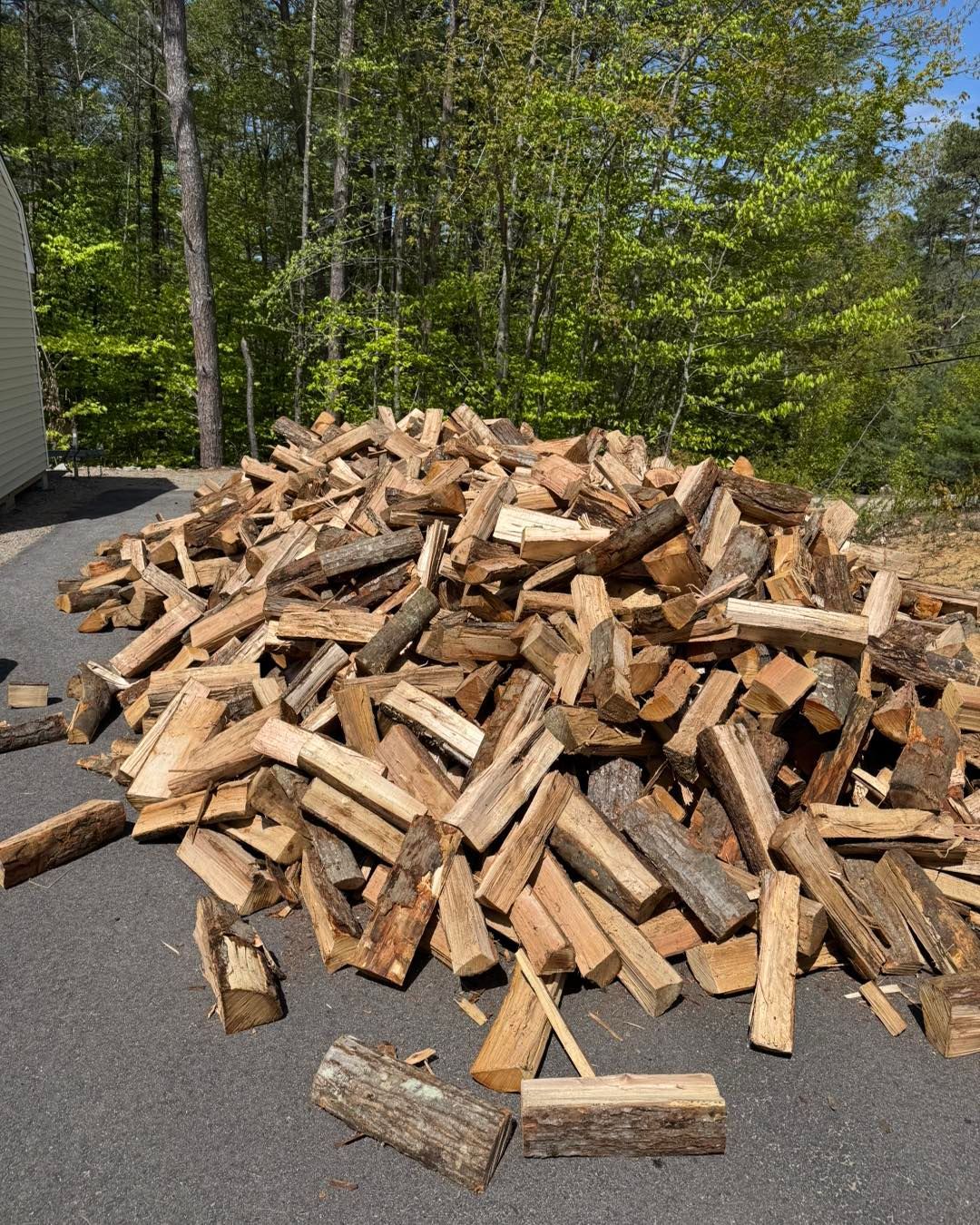 A pile of wood is sitting on the side of the road.