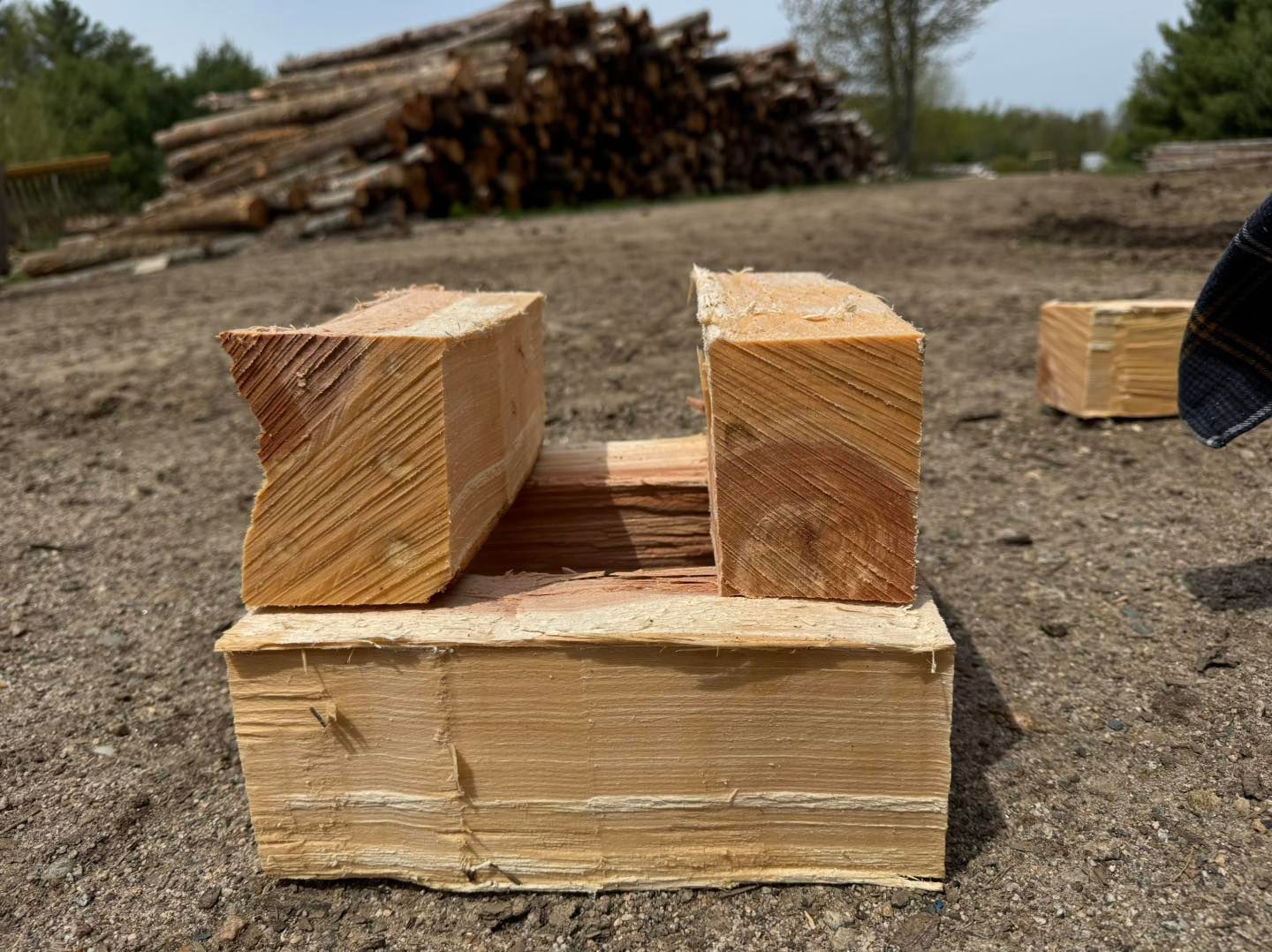 Two pieces of wood are sitting on top of each other on the ground.