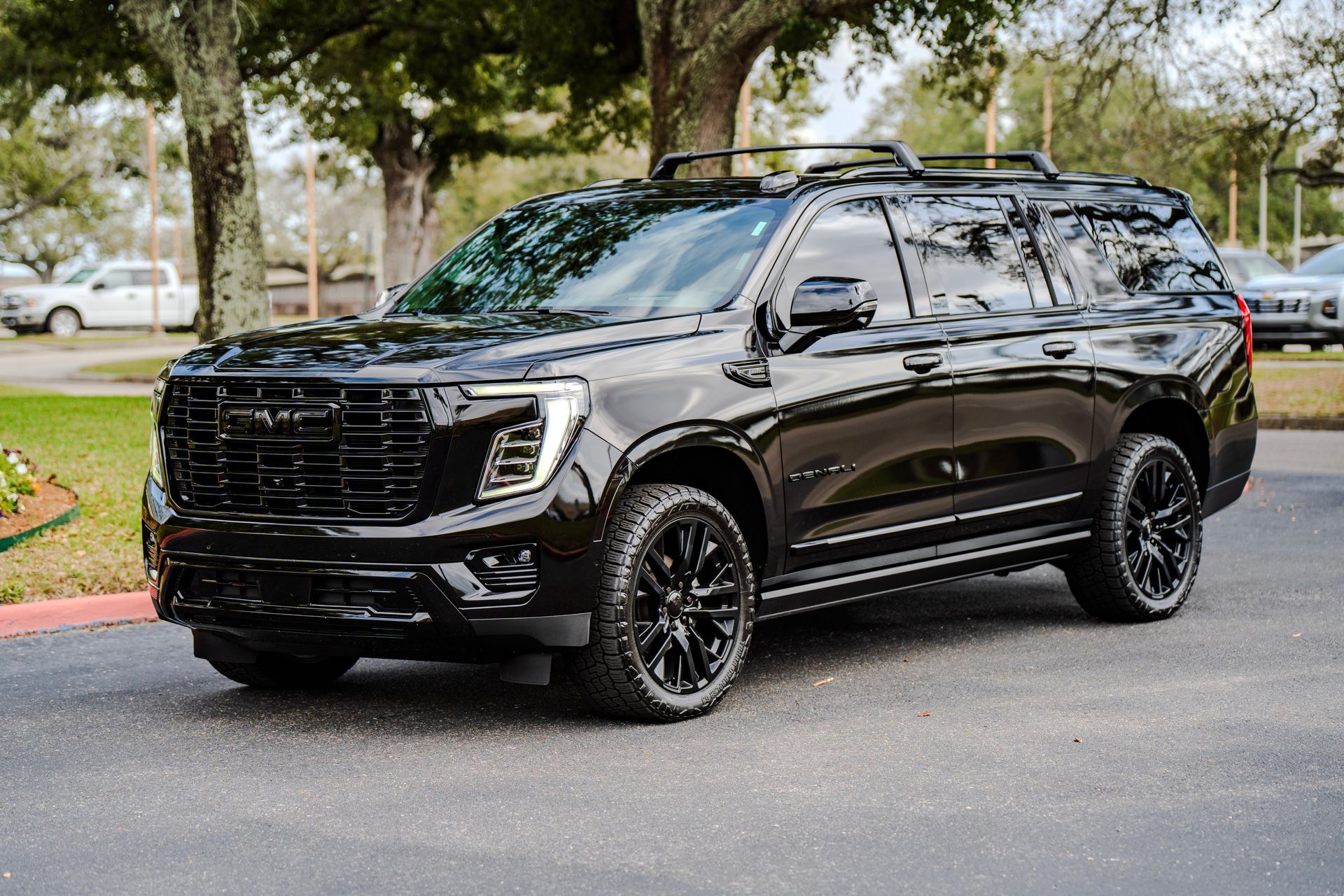 A man and a woman are standing next to a black car.