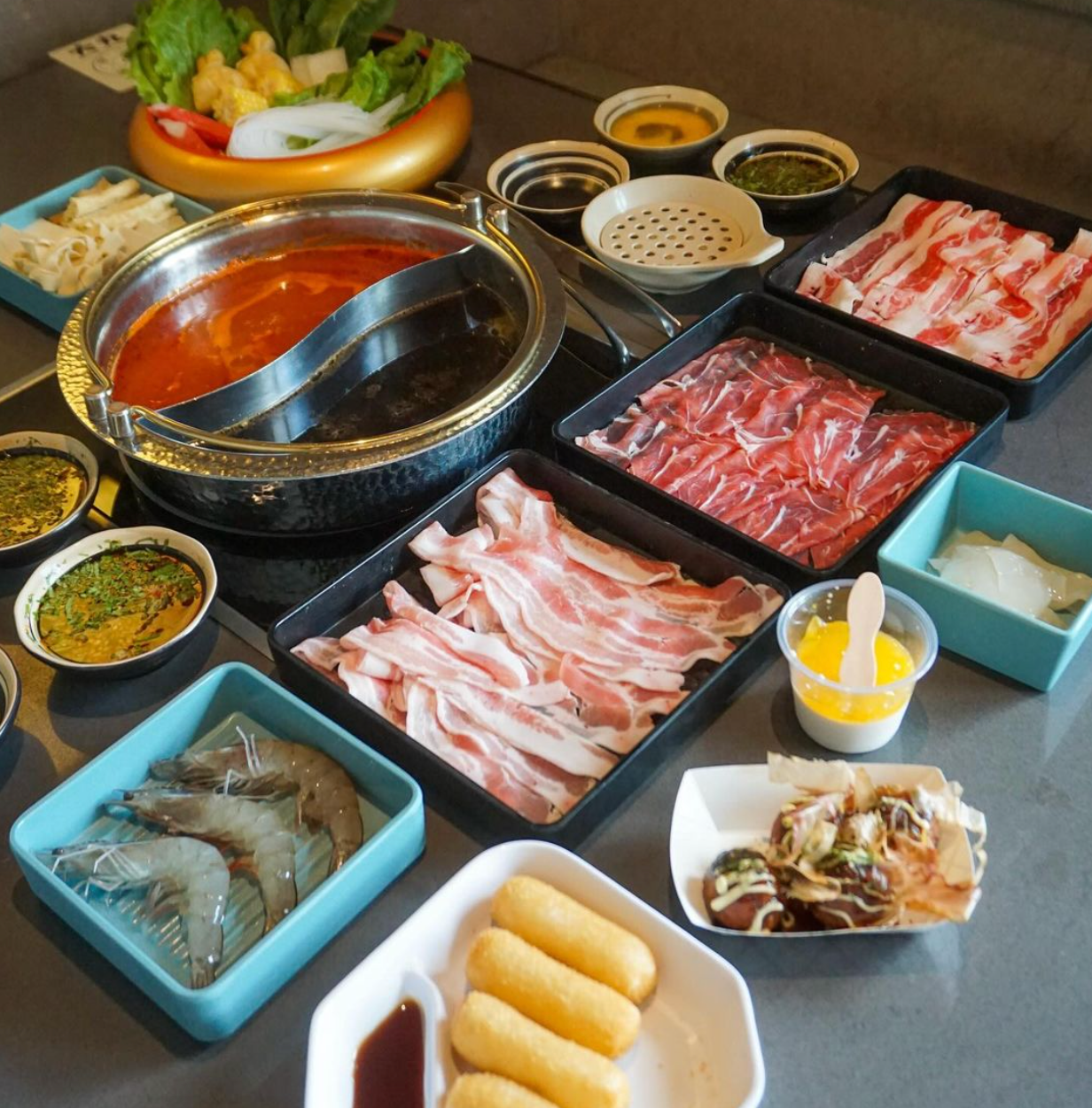 A table topped with a variety of meats and sauces