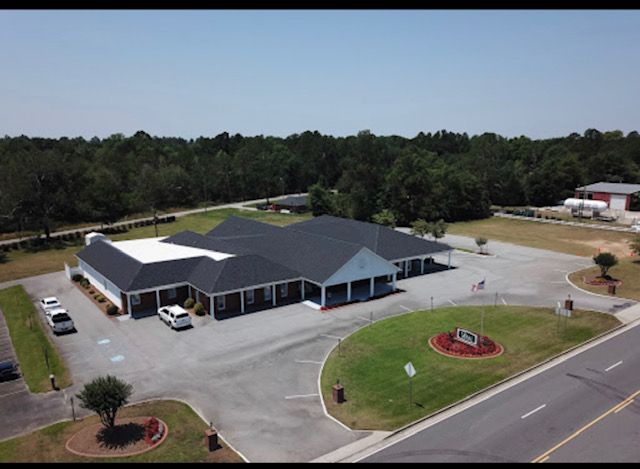 an aerial view of a large building with cars parked in front of it