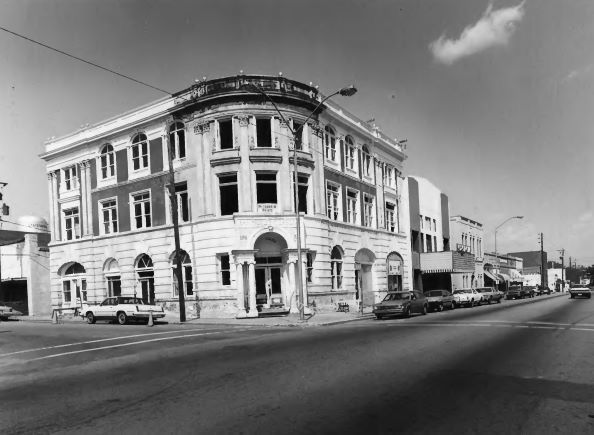 a black and white photo of a building on the corner of a street