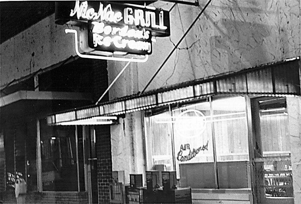 a black and white photo of a restaurant called miles mac grill