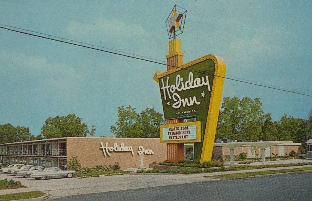 a picture of a holiday inn with cars parked in front of it