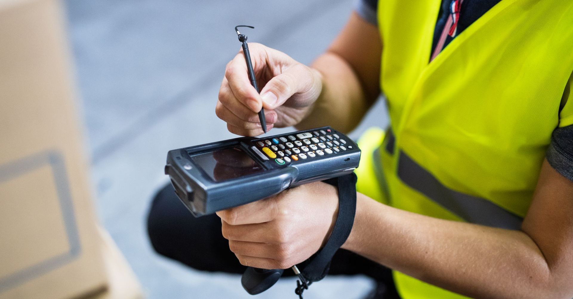 This is an image of a warehouse worker entering inventory information into a mobile scanner.