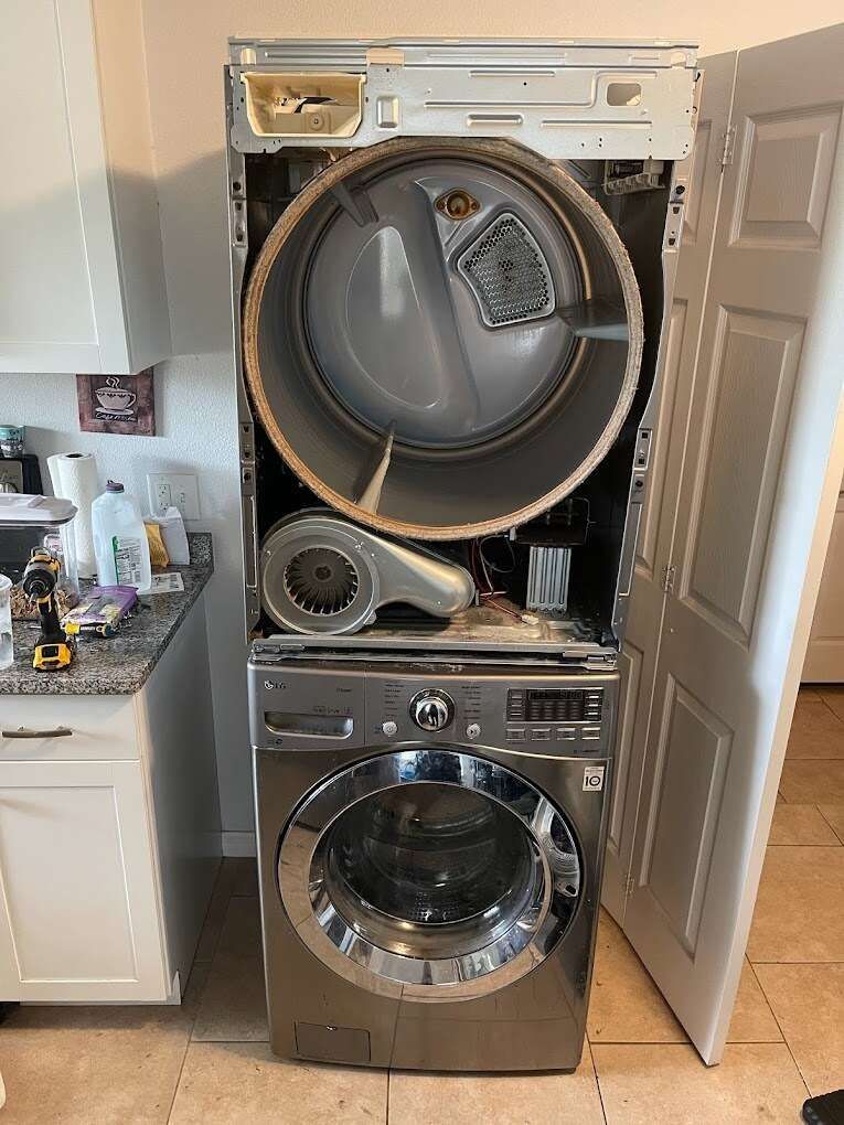 a washer and dryer are stacked on top of each other in a kitchen .