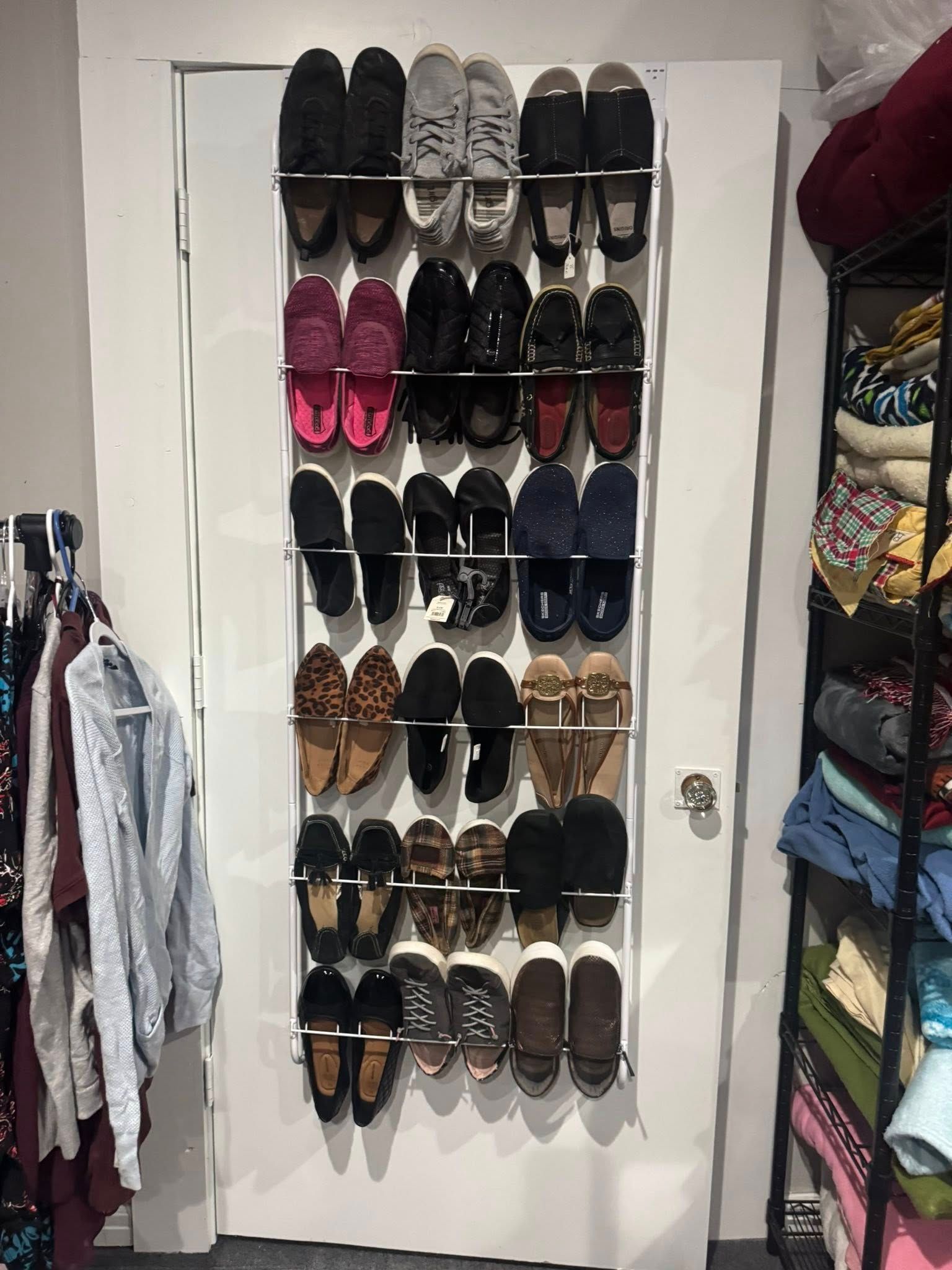 Over-the-door shoe organizer filled with assorted shoes in a closet