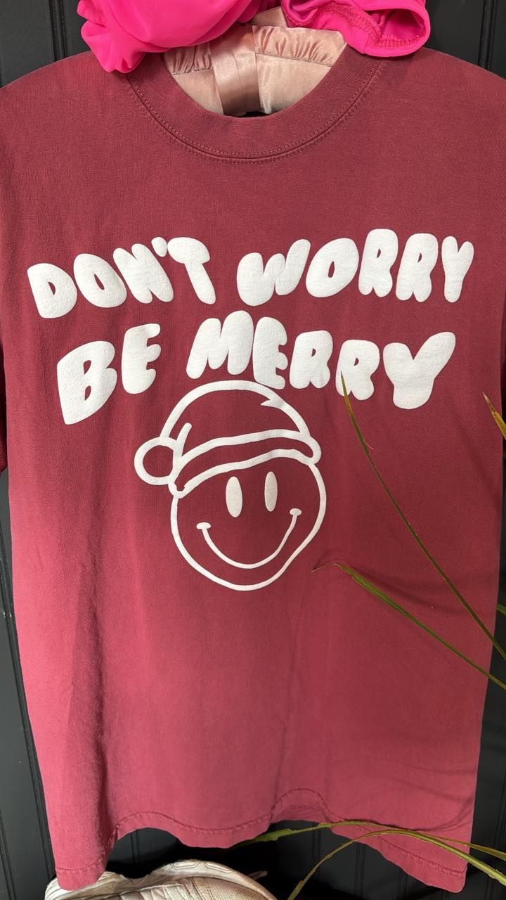 Maroon sweatshirt with “DON’T WORRY BE MERRY” text and a smiling Santa hat graphic