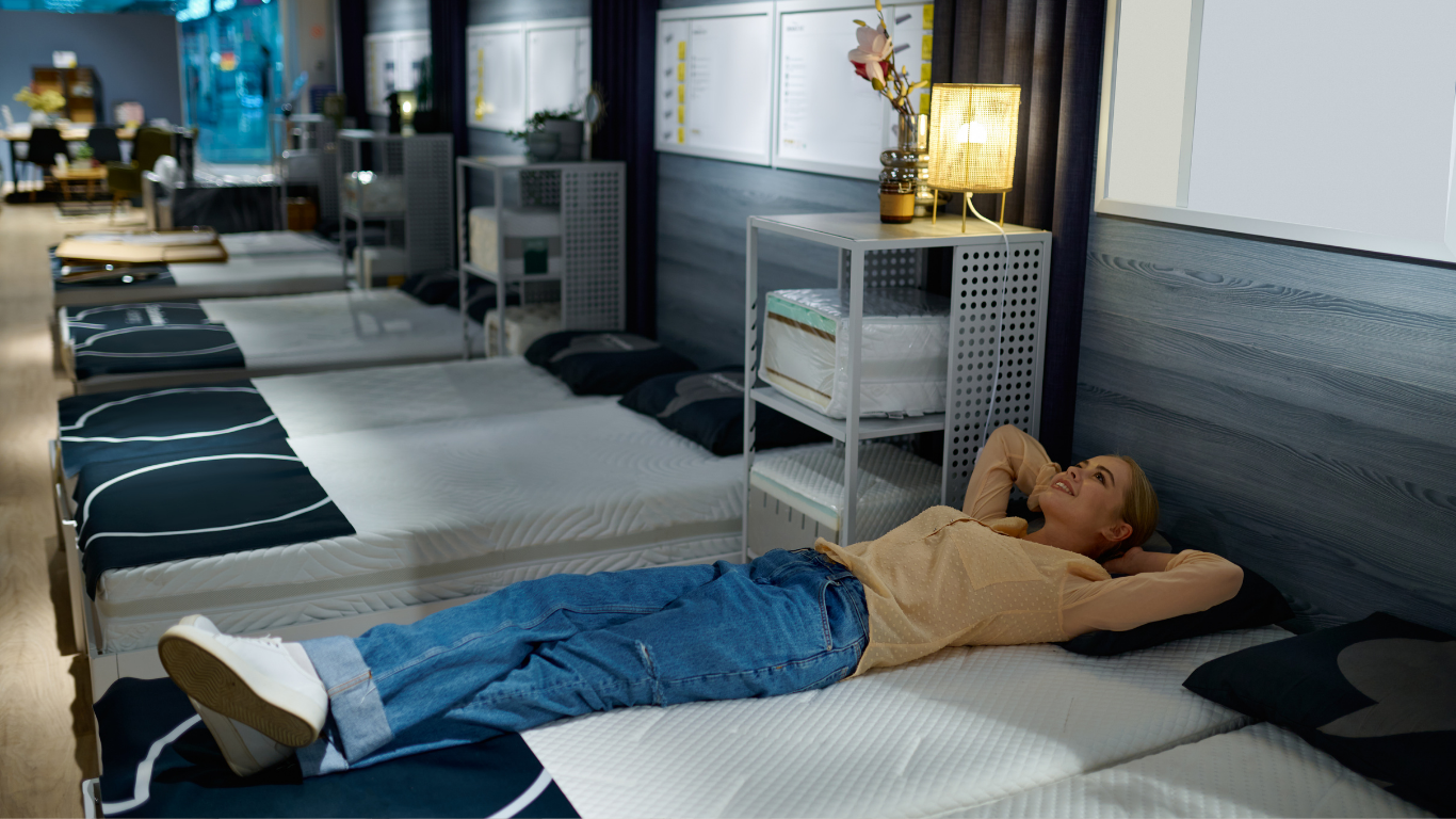 Person lying on a massage table in a spa room, with rows of beds and towels in the background