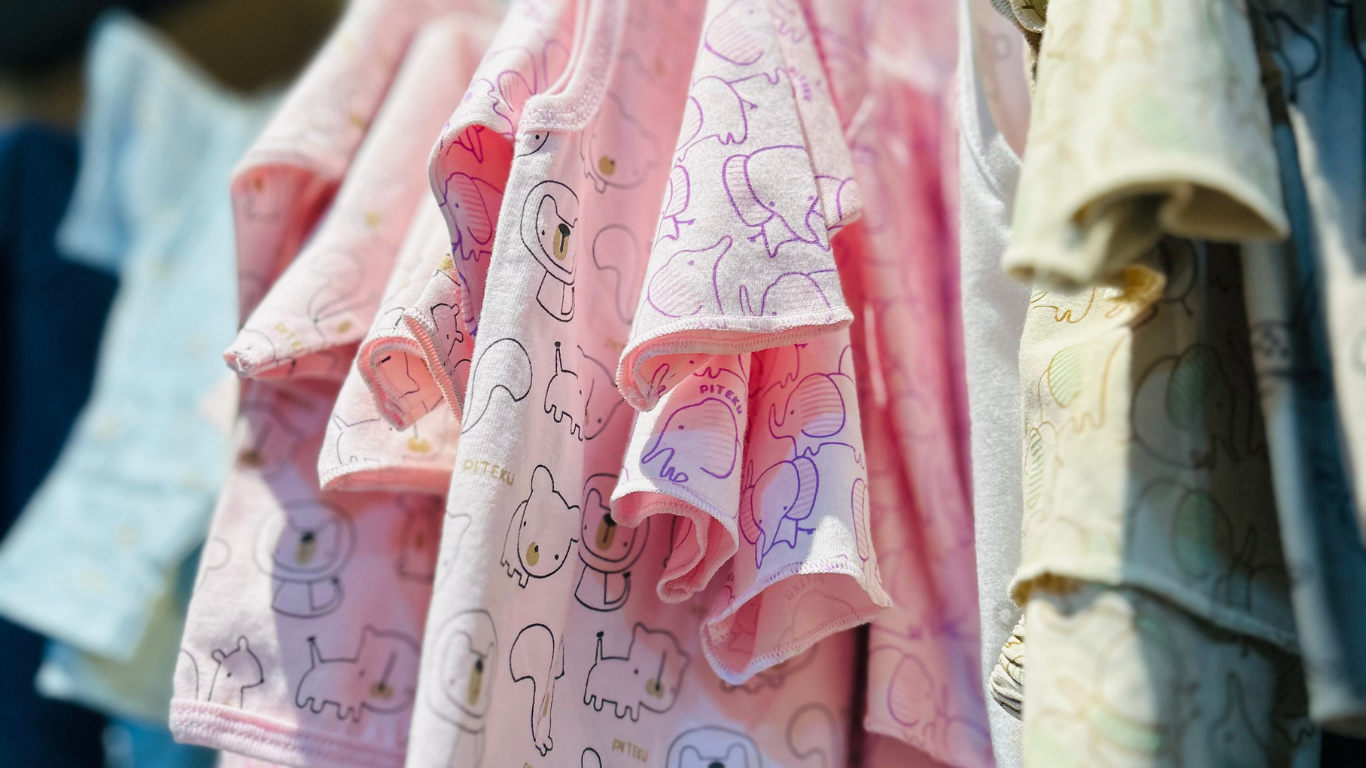 Pink and cream patterned shirts hanging on a clothes rack outdoors