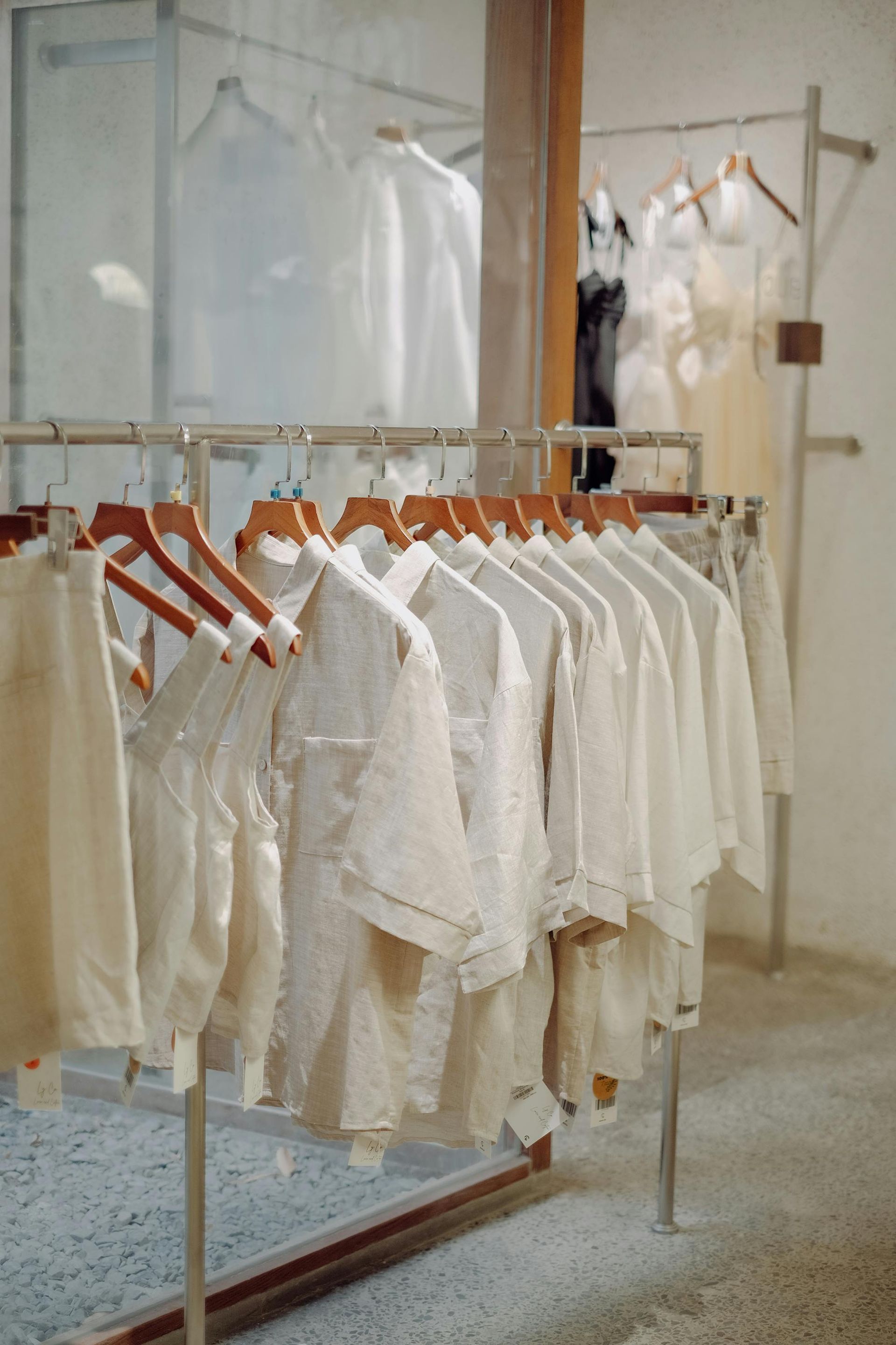 Racks of white clothing hanging in a bright boutique or laundry display