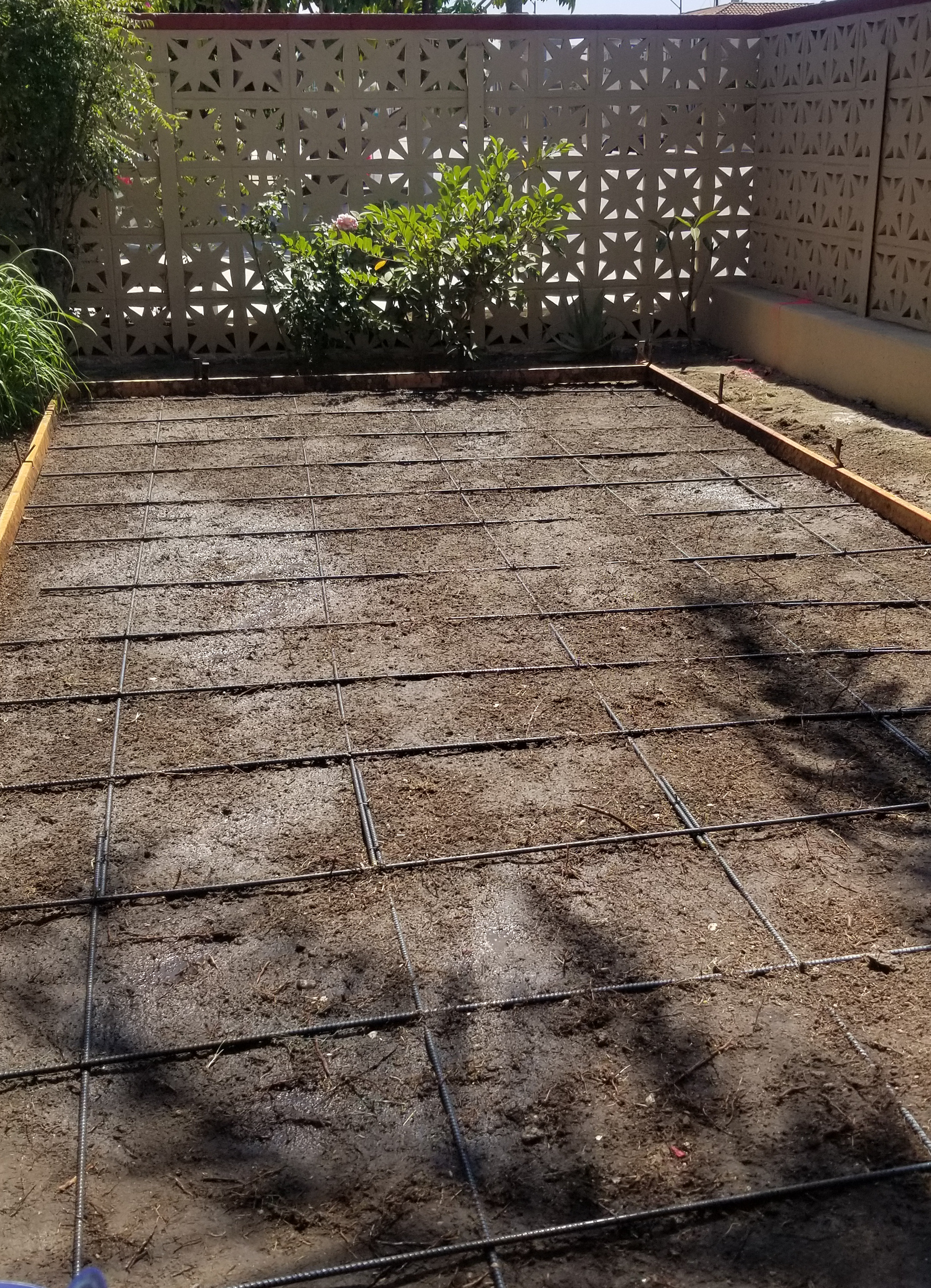 A concrete driveway with a fence in the background