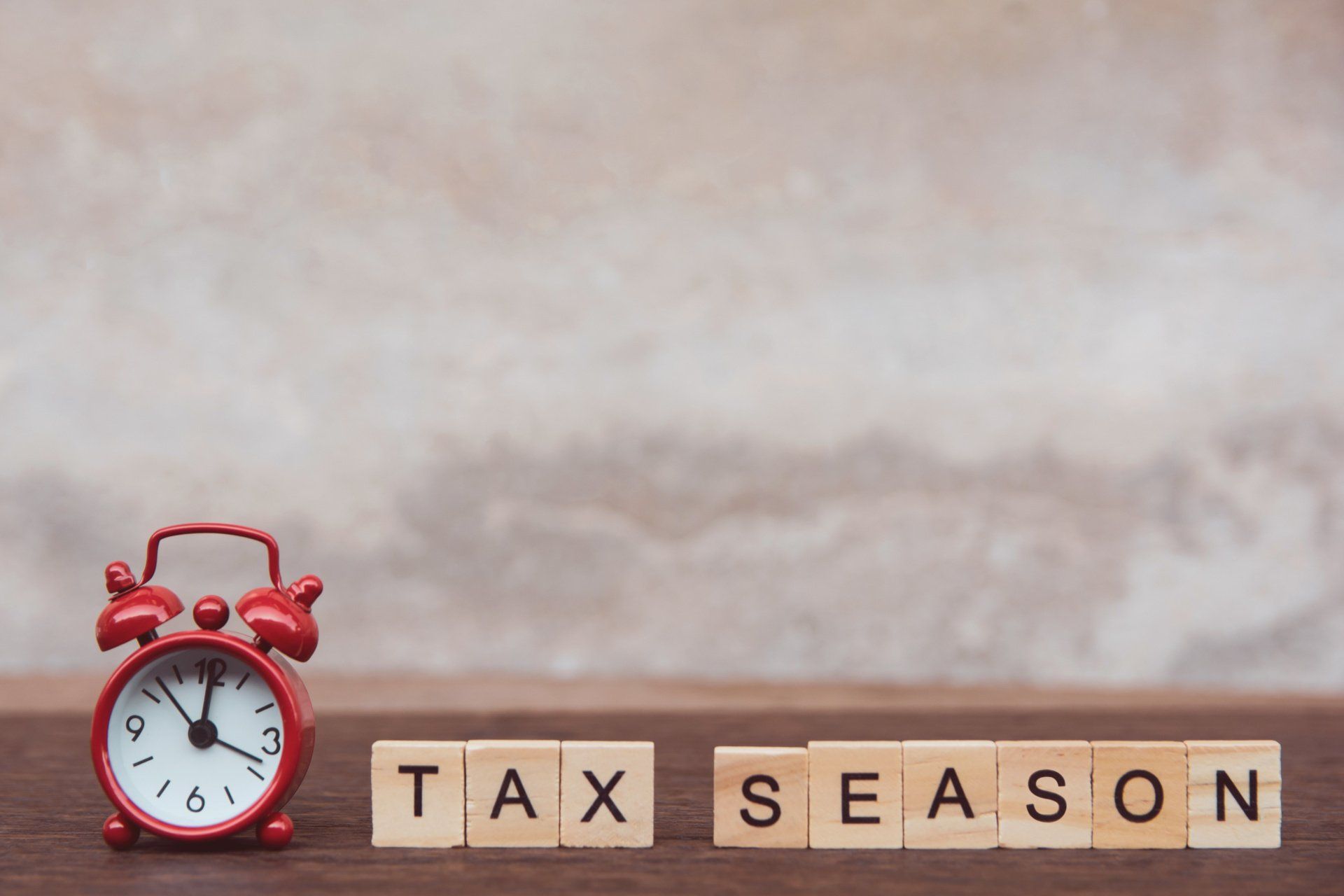 tax season in wooden blocks with red alarm clock