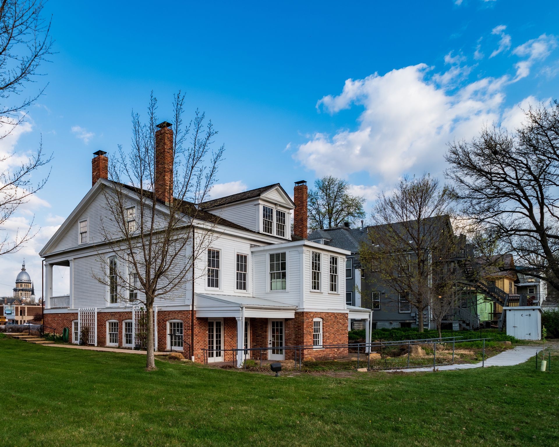 A large brick house with a clock on the top of it