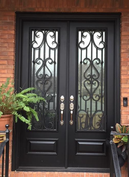 large black metal door with decorative design on the window