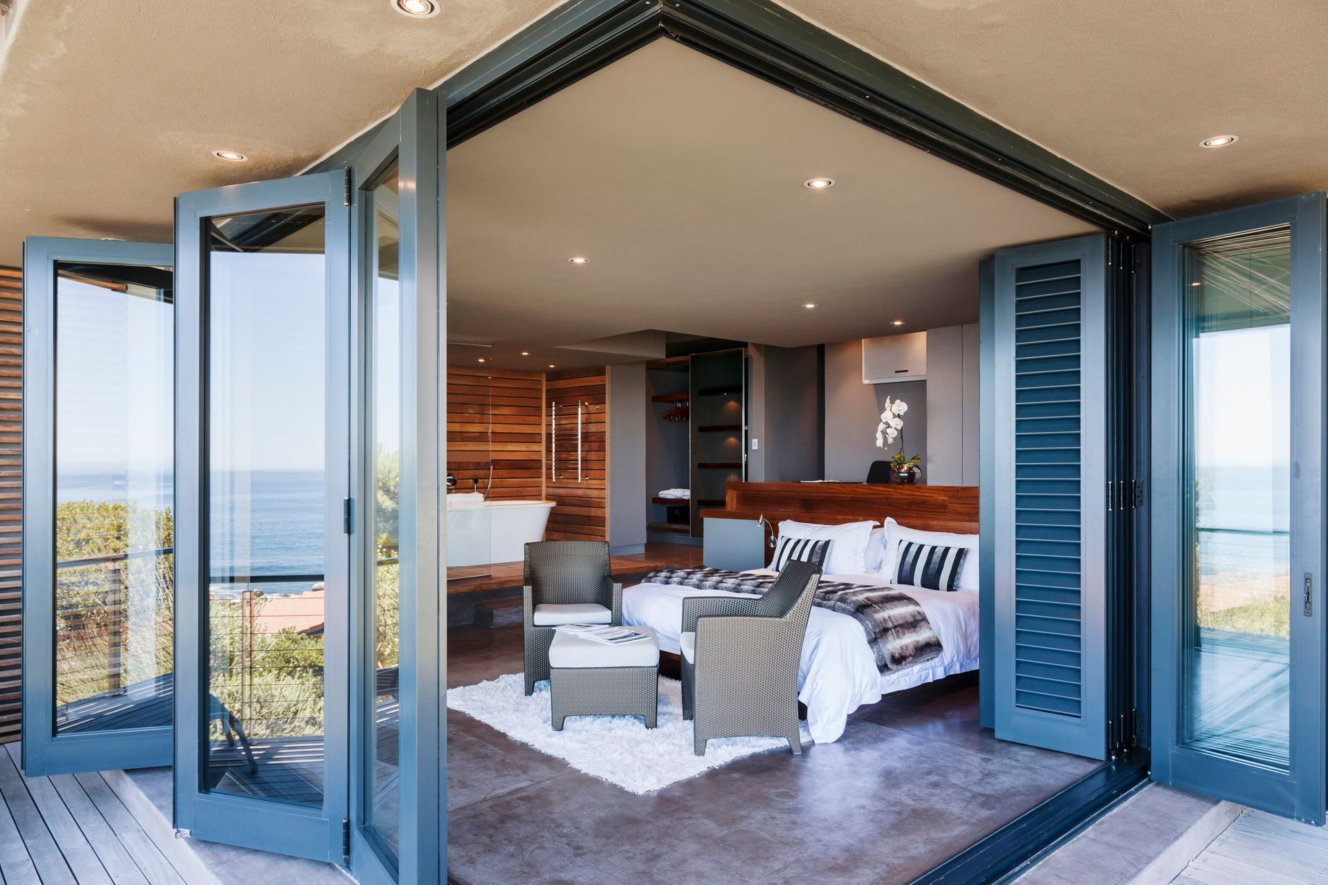 A bedroom with a king size bed and a view of the ocean