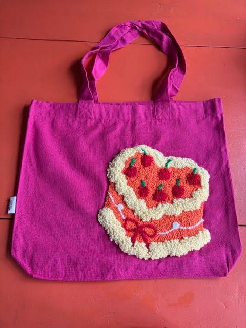 Roze draagtas met een hartvormige taartapplicatie.