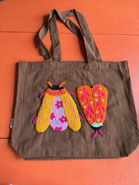 Bruine draagtas met geborduurde insectenmotieven in roze, oranje en geel.