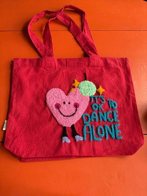 Rode draagtas met een lachend hartje en de tekst 