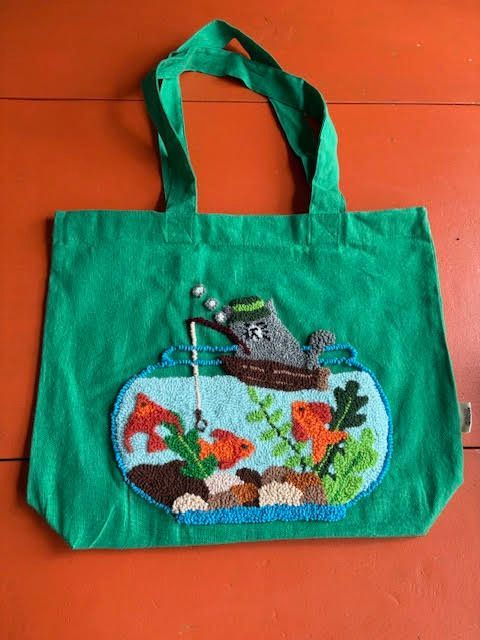 Groene draagtas met een geborduurd vissenkommotief: een grijze nijlpaard die vist tussen kleurrijke vissen en planten.