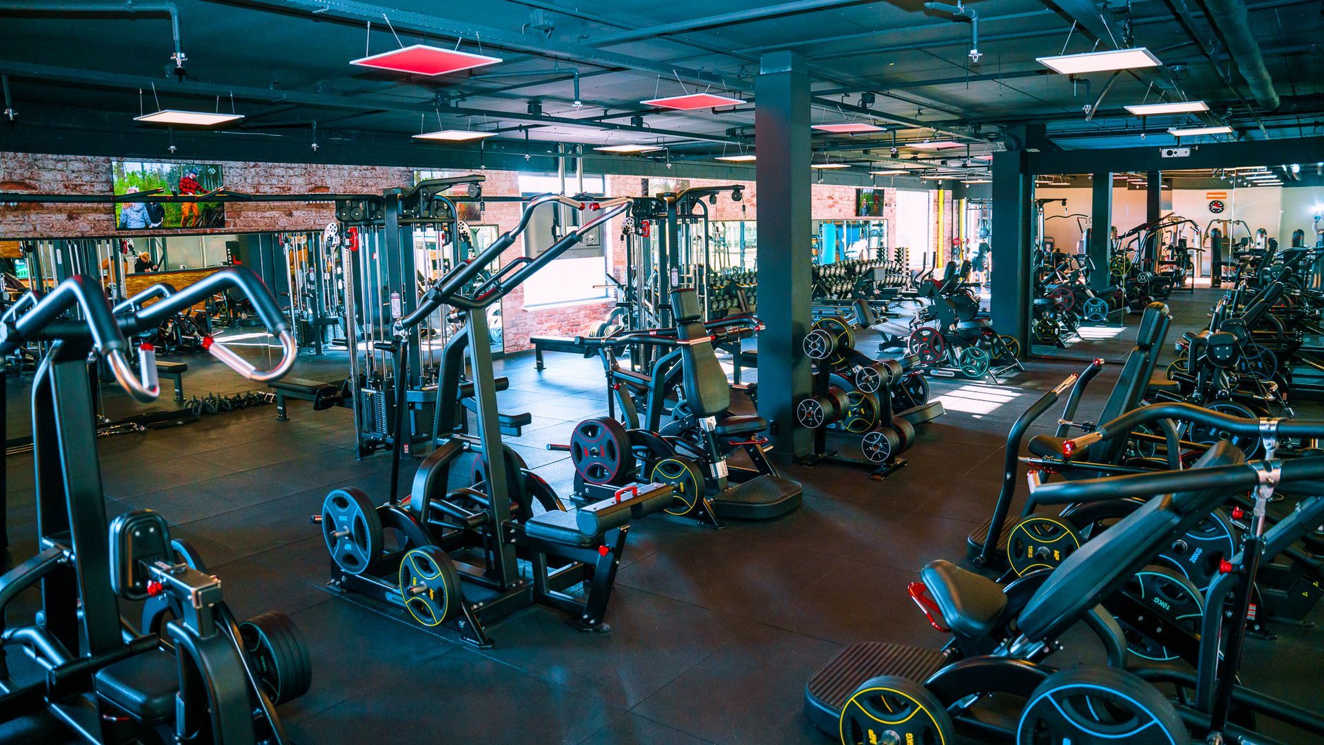 Een grote fitnessruimte vol met veel fitnessapparatuur.
