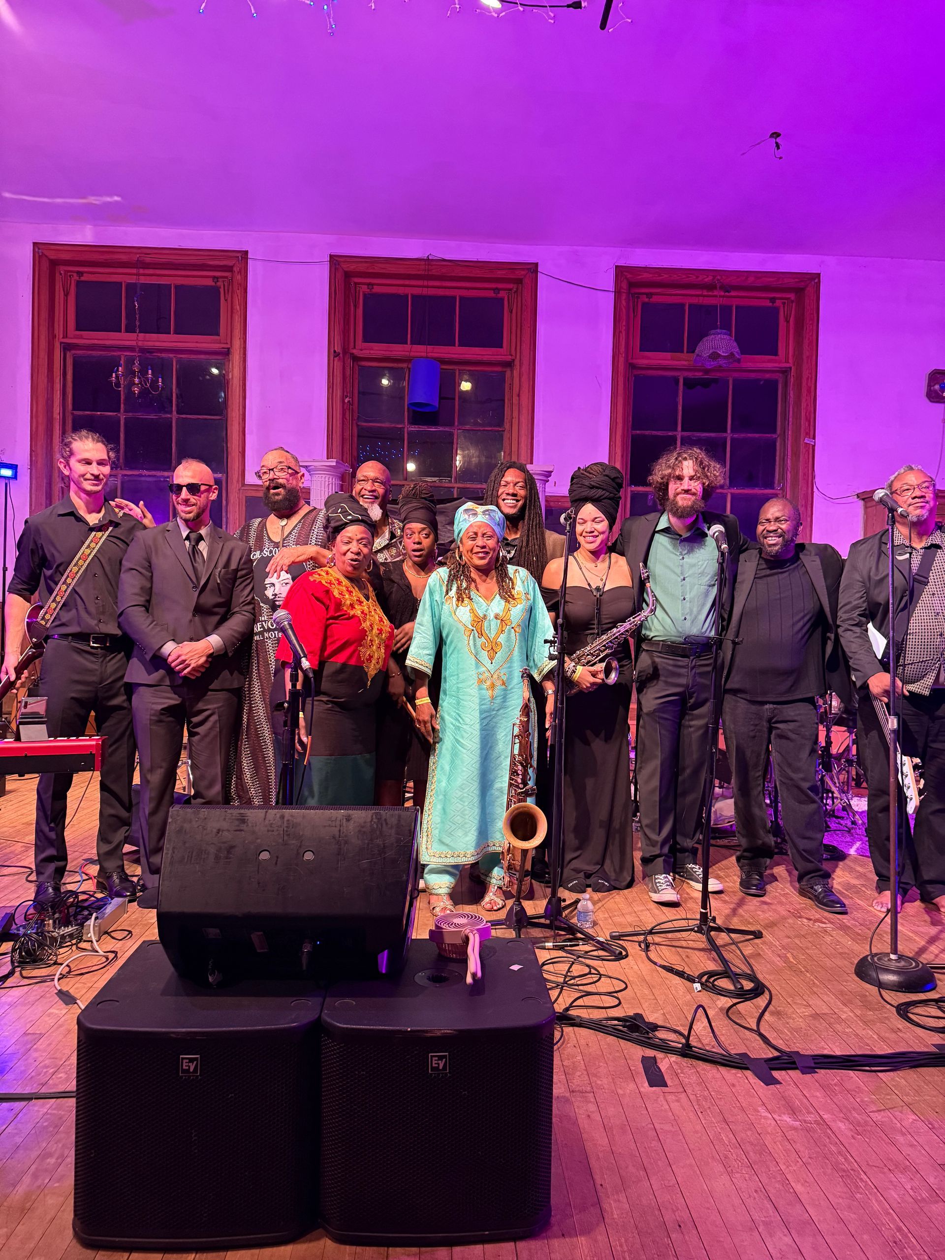 A woman wearing a green shirt and a turban is flexing her muscles.