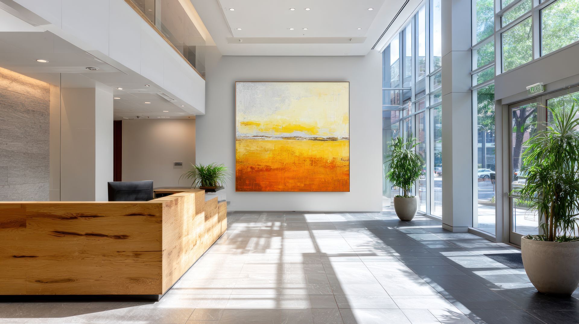 Hall d'entrée moderne avec une peinture abstraite orange, un comptoir d'accueil en bois et des baies vitrées.