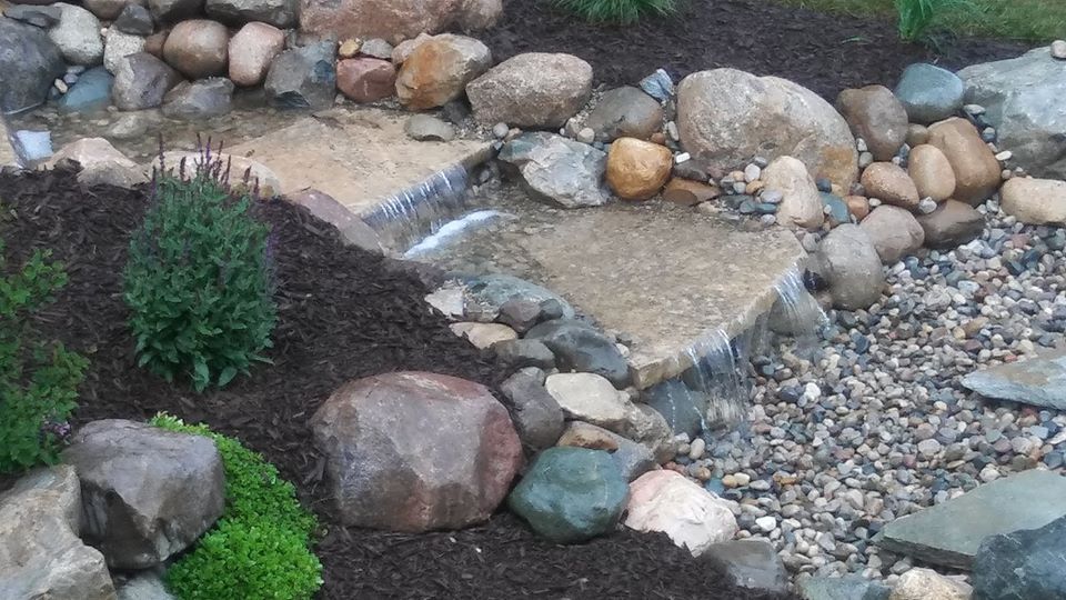 Close up of waterfalls next to stones— Clarkston, MI — Lowries Landscape Inc