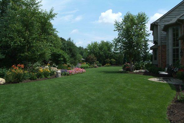 Wide grassy area with flowers and trees — Clarkston, MI — Lowries Landscape Inc