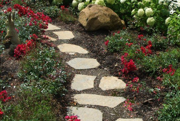 Stone walkway next to flowers and large rock — Clarkston, MI — Lowries Landscape Inc