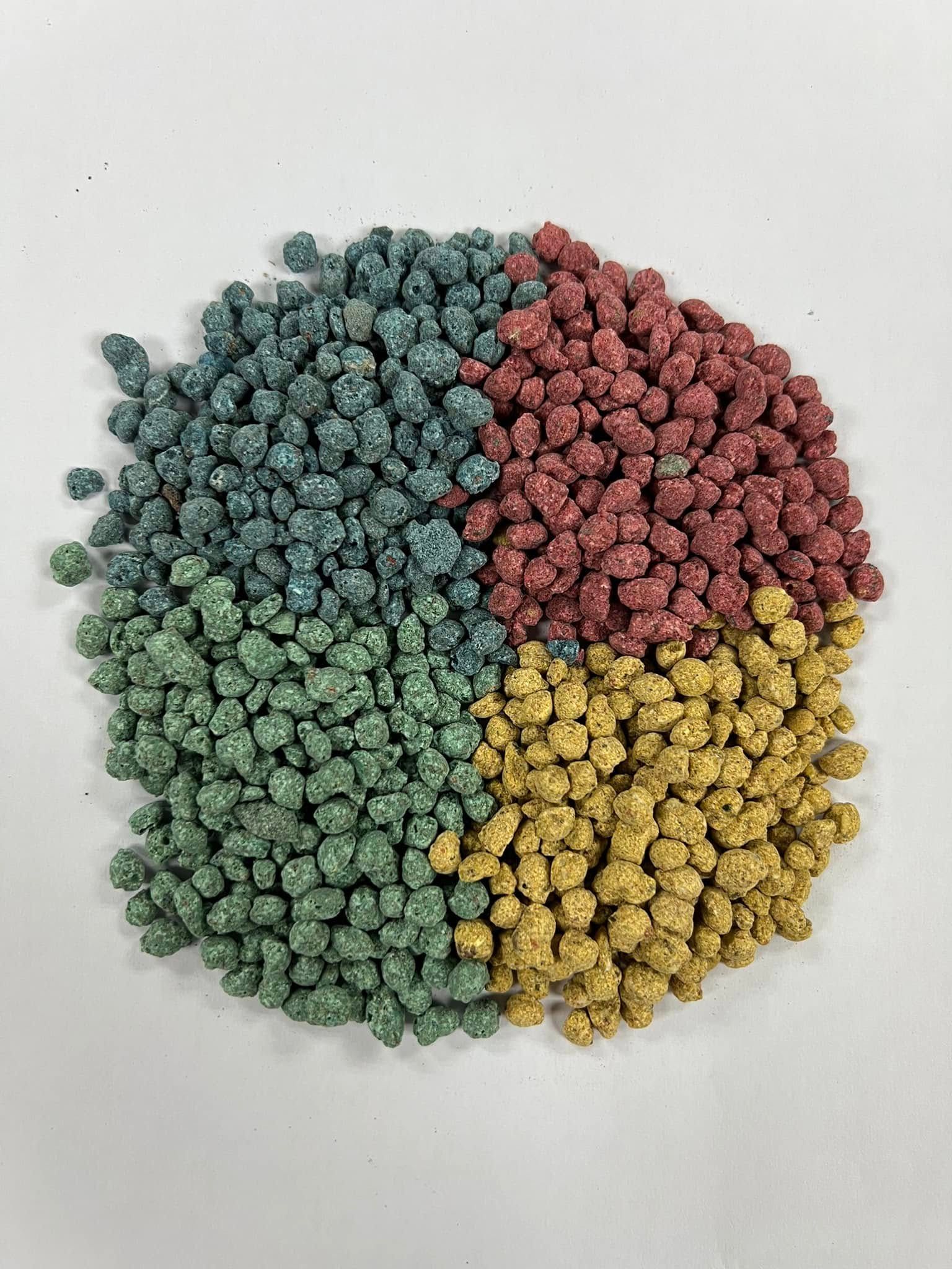 A pile of different colored grains in a circle on a white surface.