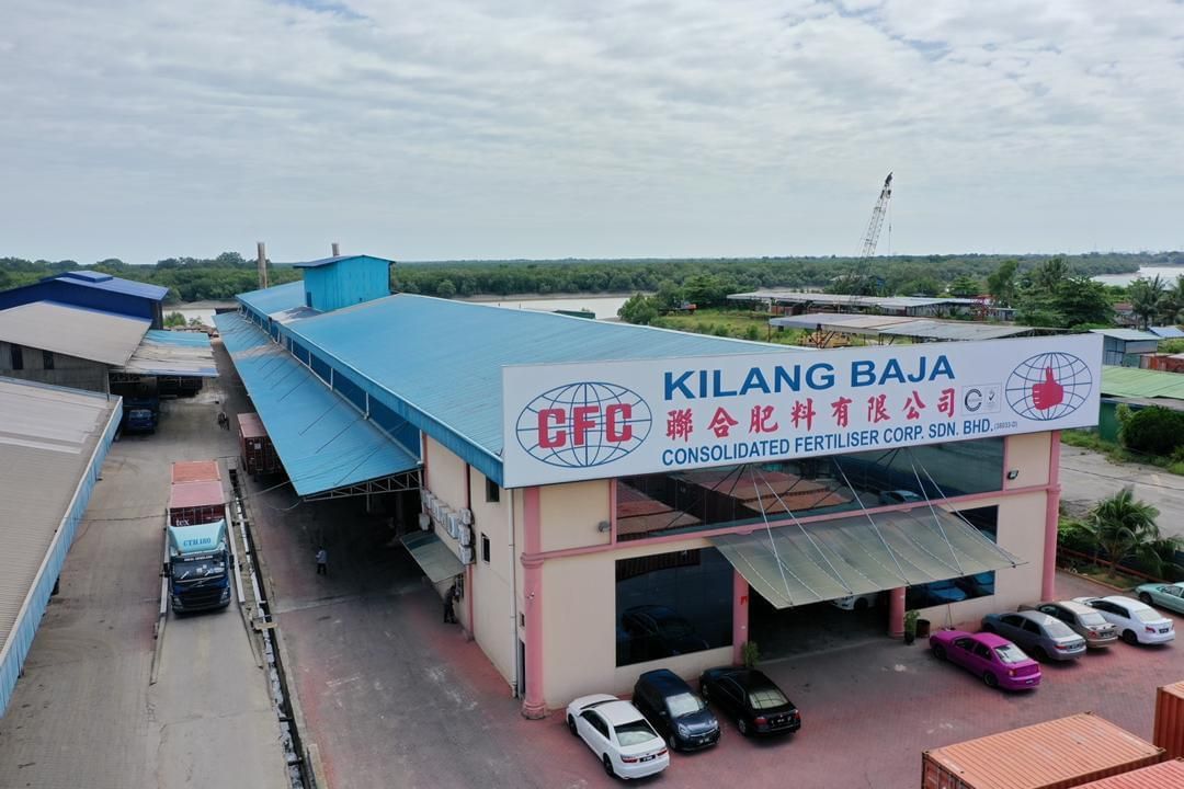 Pemandangan dari udara bangunan besar dengan kereta diletakkan di hadapannya.