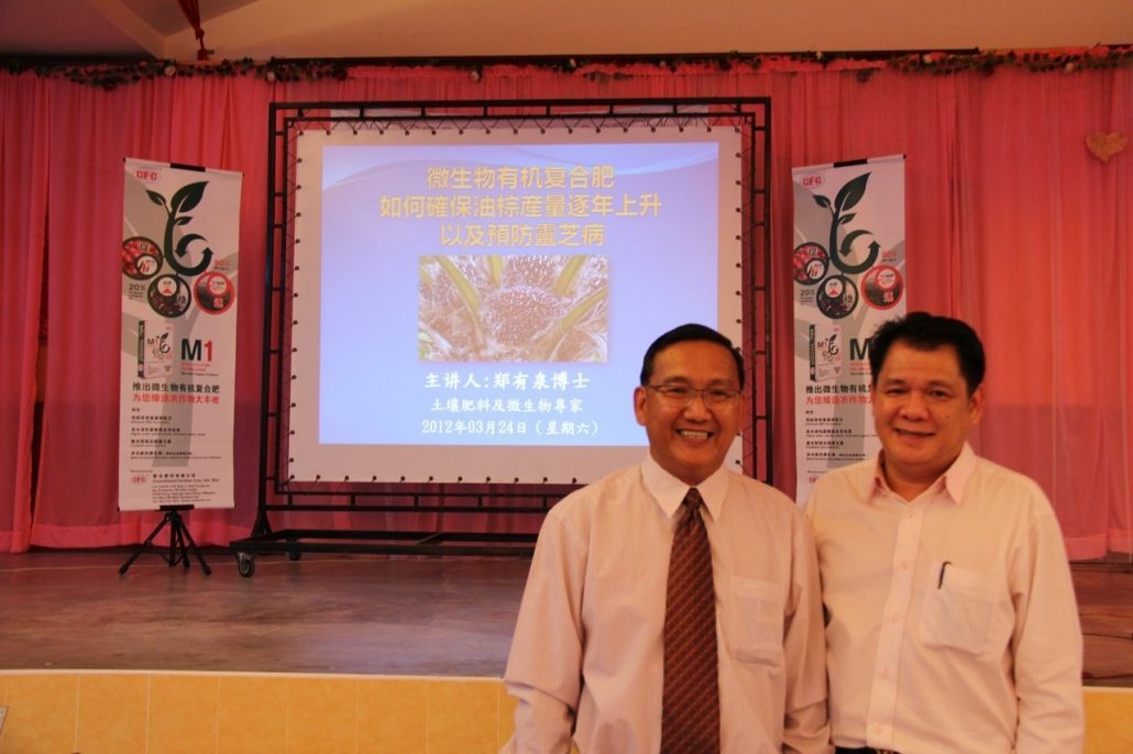 两名男子在投影仪屏幕前摆姿势拍照