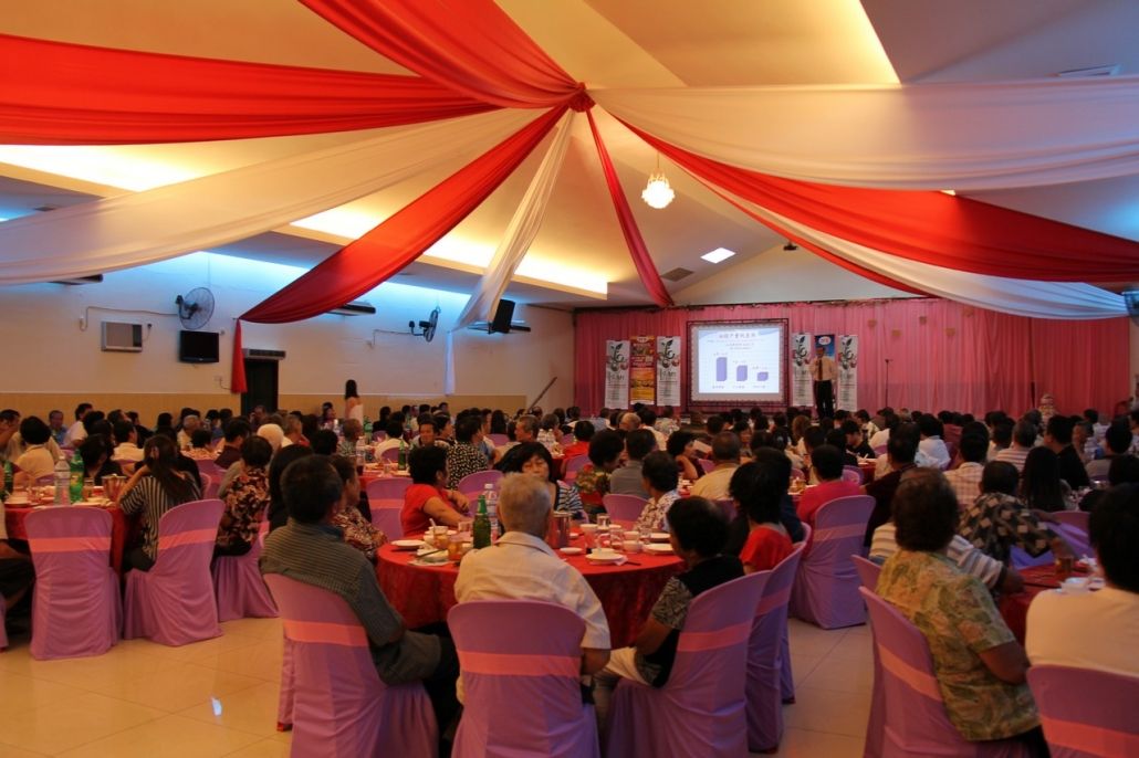 一大群人坐在一间大房间里的桌子旁