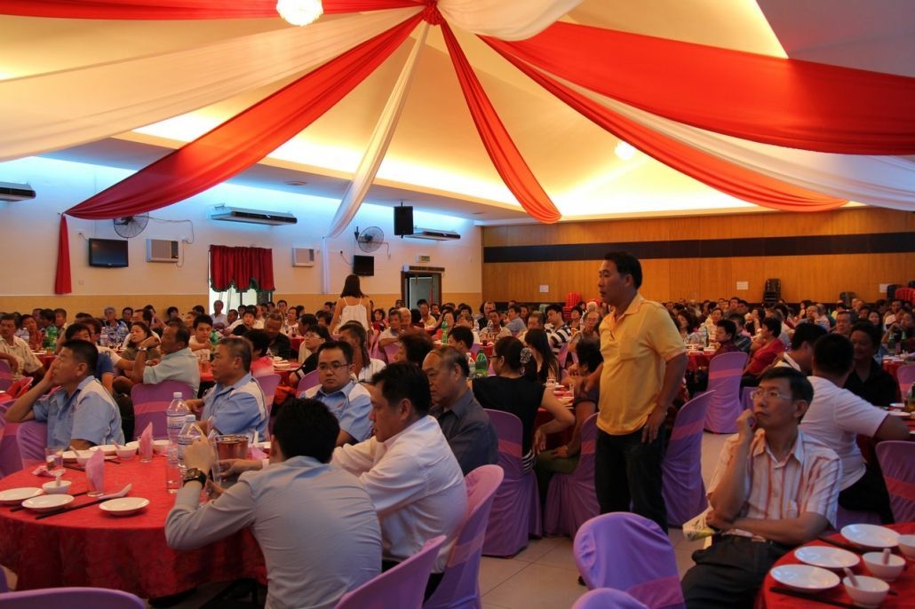 一大群人坐在一间大房间里的桌子旁