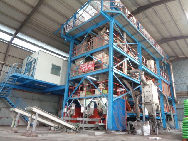 A large blue and white building with stairs in a warehouse.