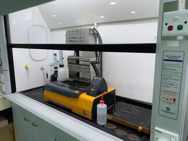 A yellow machine is sitting on a counter in a lab.