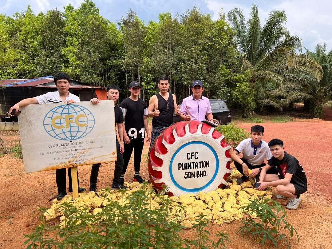 一群年轻男子正在一面大鼓前摆姿势拍照。