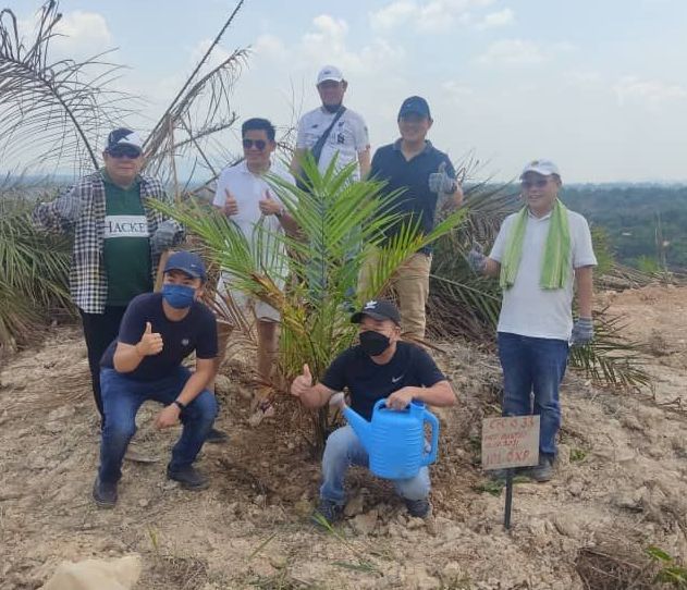 一群男人围着一棵树,其中一名男子正在给树浇水