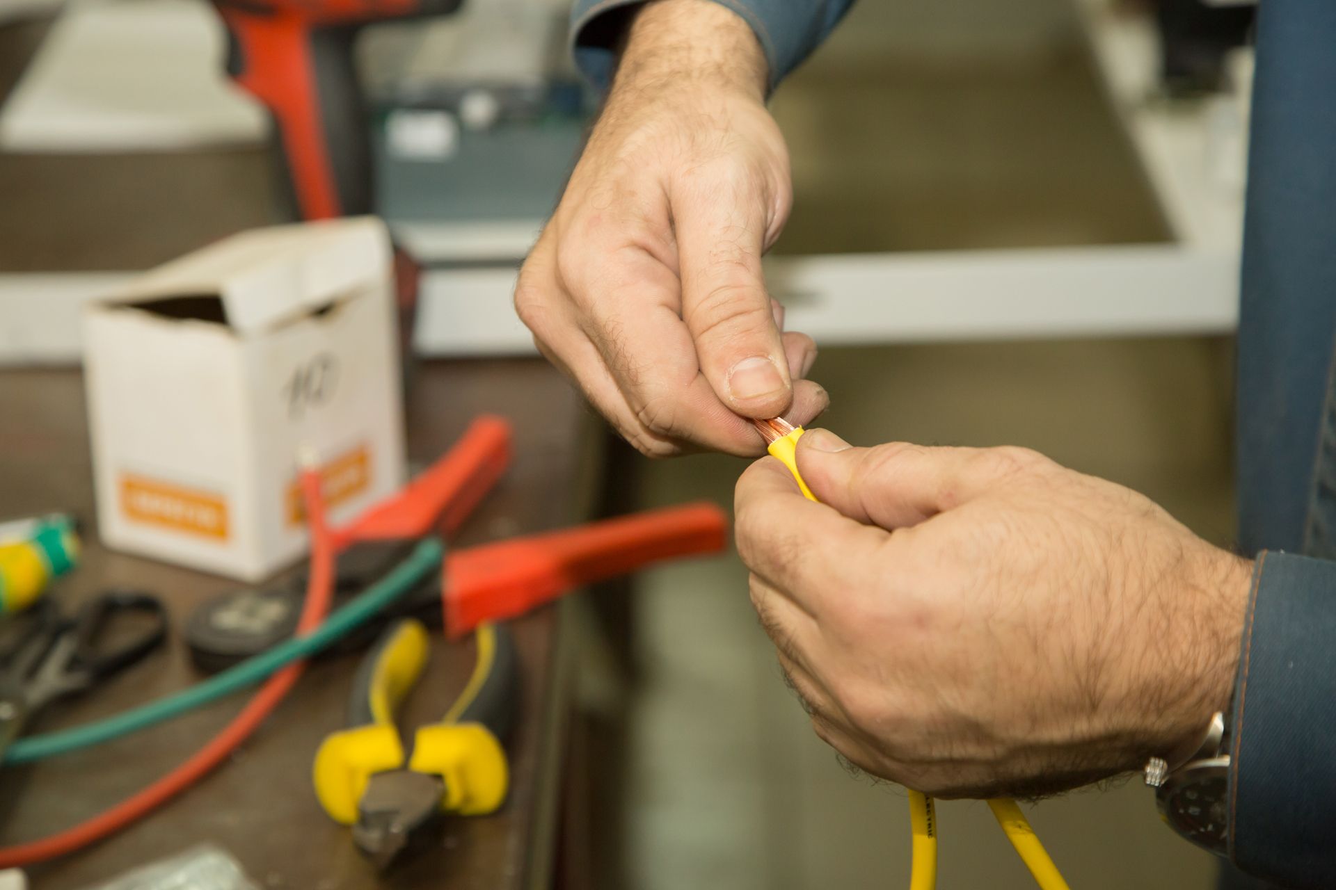 A Man is Holding a Yellow Wire in His Hands