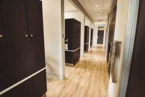 A long hallway with wooden floors and cabinets in a dental office.