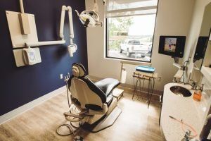 A dental office with a dental chair and a sink.
