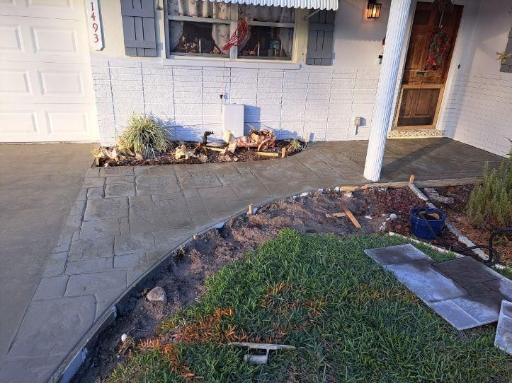 New concrete walkway and landscaping in front of a house.