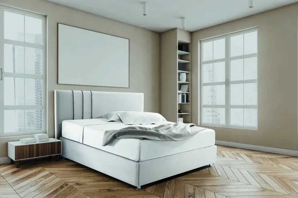 Una camera da letto con un letto, un comodino, degli scaffali e un quadro sulla parete.