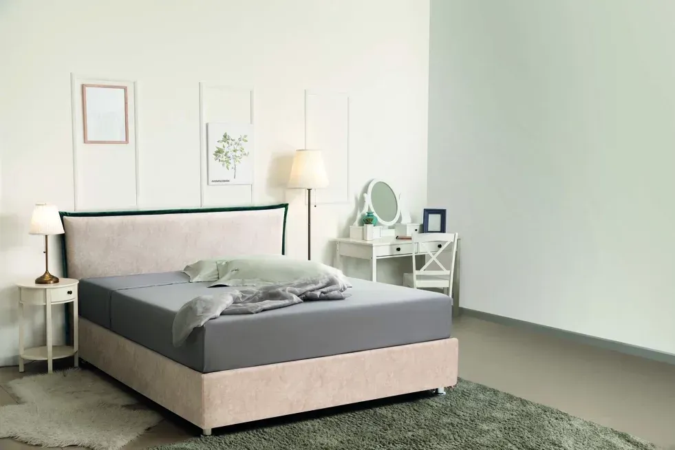 Una camera da letto con un letto, un comodino, una lampada e uno specchio.