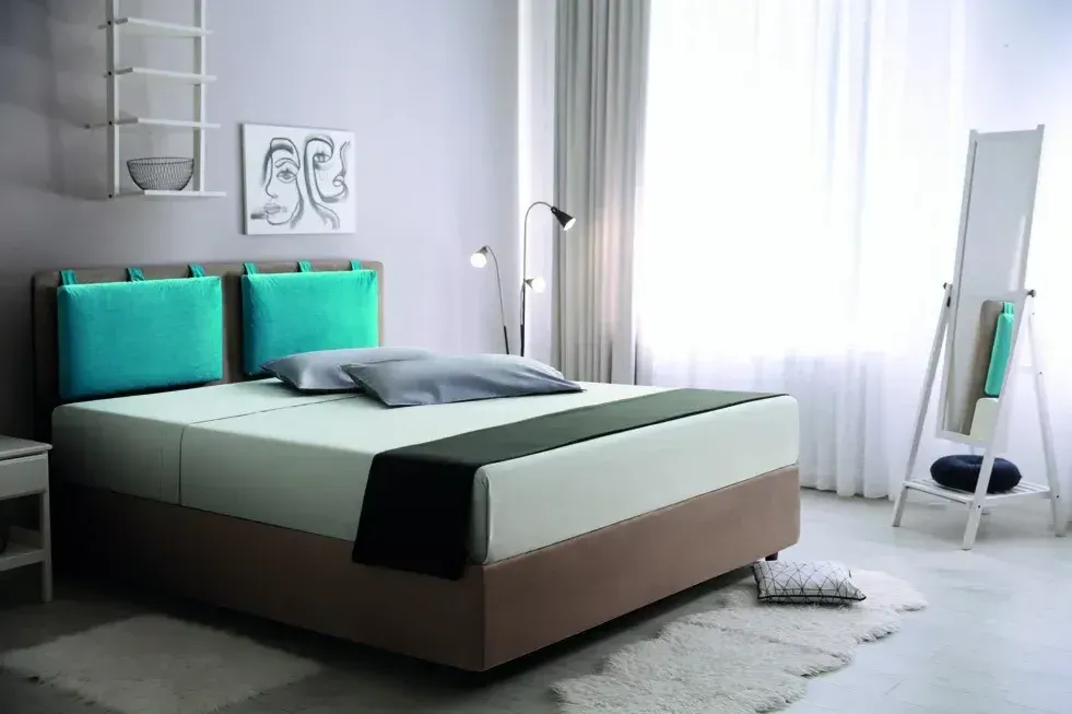 Una camera da letto con un letto, un comodino, uno specchio e una finestra.