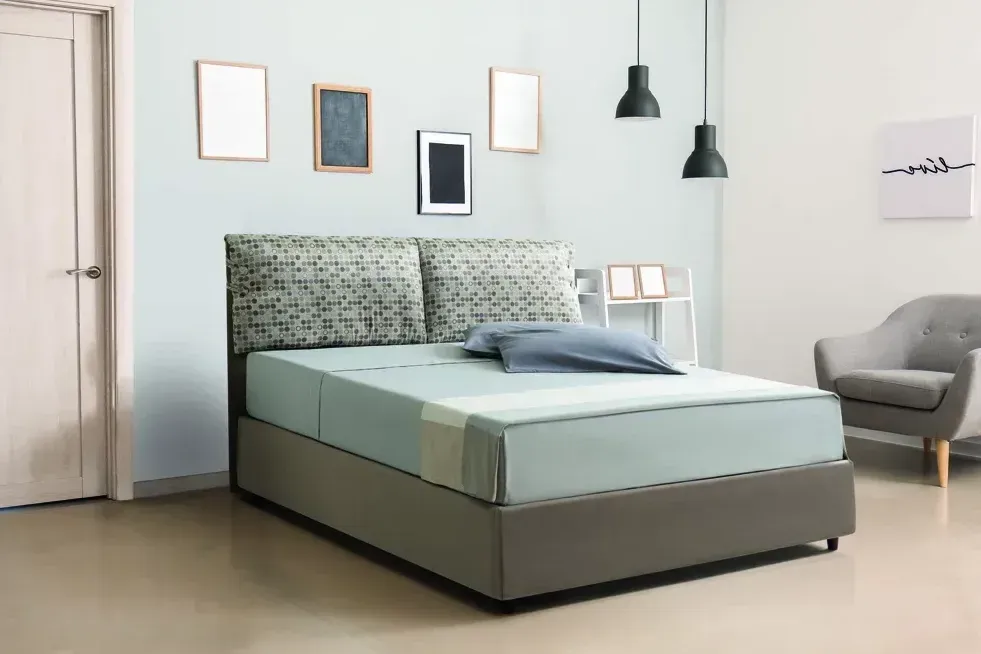 Un letto è posizionato in una camera da letto accanto a una sedia.