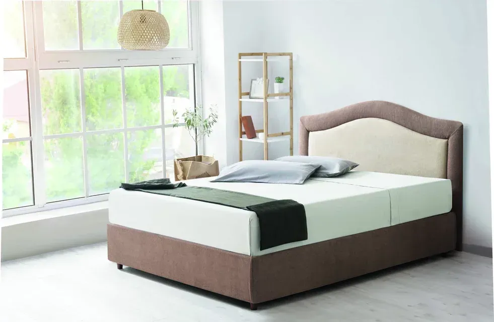 Un letto è posizionato in una camera da letto accanto a una finestra.